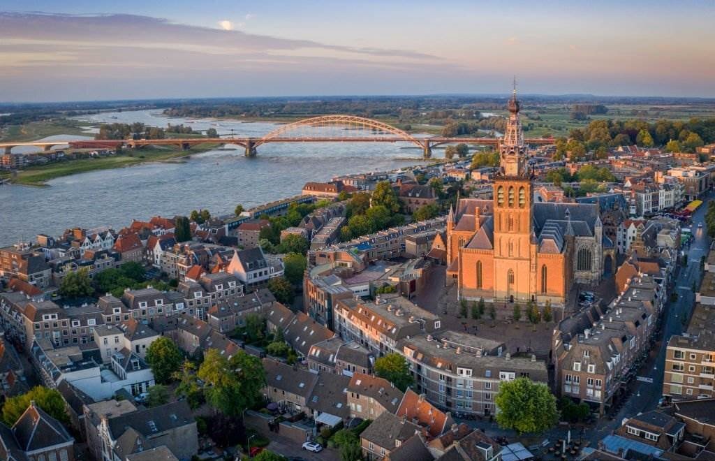 Netherlands, Gelderland, Nijmegen, Aerial view of Saint Stephens Church and surrounding buildings at dusk - Best Time to Visit Europe - Planet Travel Advisor Netherlands, Gelderland, Nijmegen, Aerial view of Saint Stephens Church and surrounding buildings at dusk - Best Time to Visit Europe - Planet Travel Advisor