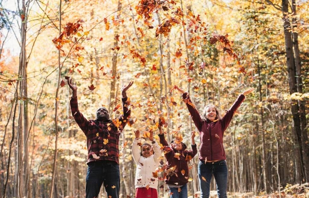 Mixed race family in a forest, throwing maple leaf, during autumn, Quebec, Canada - Best Time to Visit Canada - Planet Travel Advisor Mixed race family in a forest, throwing maple leaf, during autumn, Quebec, Canada - Best Time to Visit Canada - Planet Travel Advisor