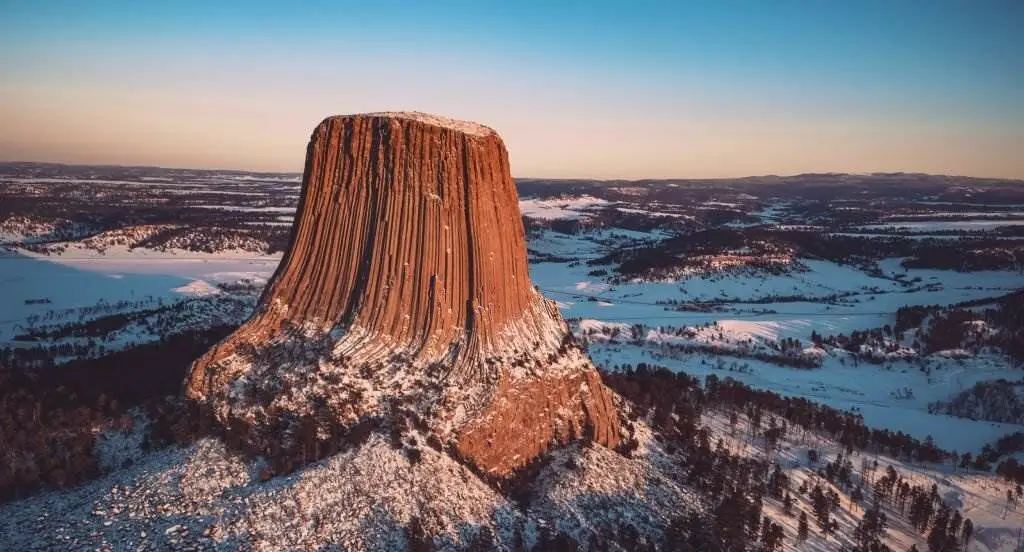 Devils Tower National Monument - Aerial View Of Devils Tower National Monument Against Sky During Sunset In Winter - Natural Attractions in USA - Planet Travel Advisor