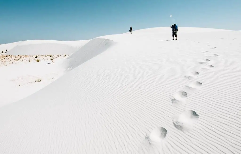 White Sands National Park - Backpackers hiking on White Sands National Monument in New Mexico. USA - Natural Attractions in USA - Planet Travel Advisor