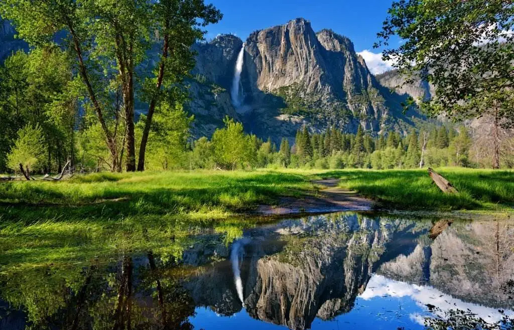 Yosemite Falls reflected perfectly in outlet of Merced River by Swinging Bridge, Yosemite National Park, California - Natural Attractions in USA - Planet Travel Advisor