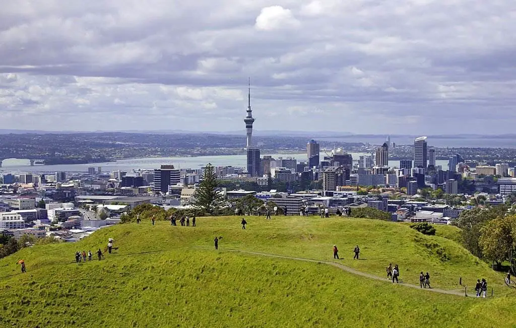 People walk around the volcanic crater on Mount Eden. New Zealand, North Island, Auckland - Best 5 Countries to Visit in 2023 With Tips - Planet Travel Advisor