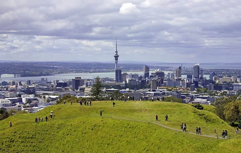 People walk around the volcanic crater on Mount Eden. New Zealand, North Island, Auckland - Best Places to Travel in March - Planet Travel Advisor