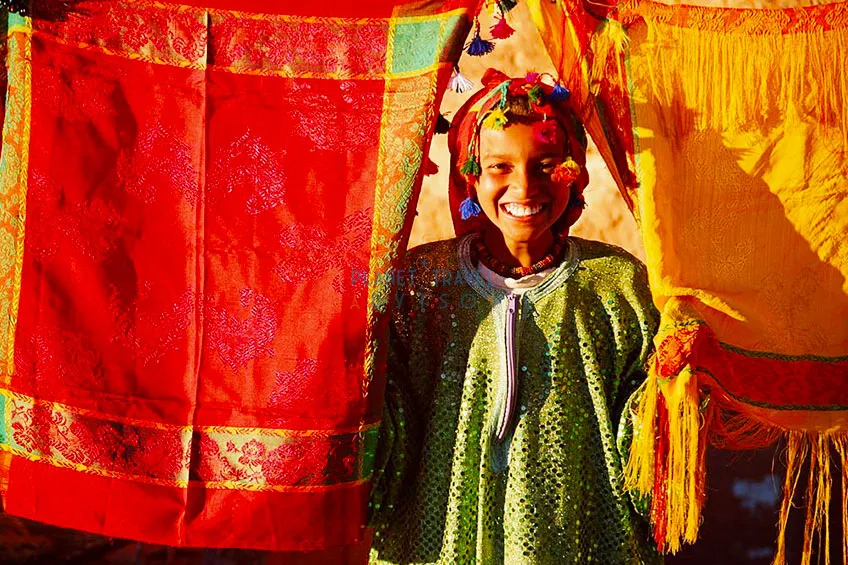 Morocco, Bedouin girl smiling, portrait - Best Time to Visit Morocco - Planet Travel Advisor